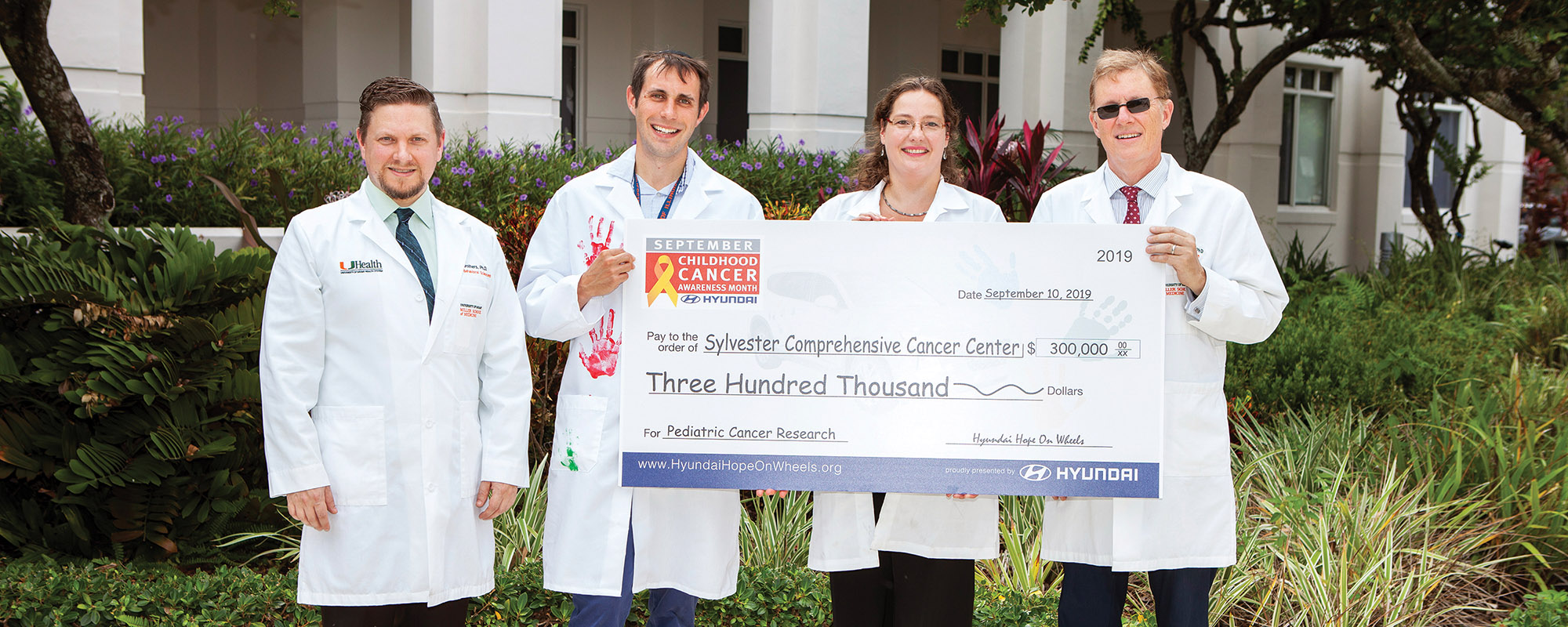 Sylvester Researchers pose with a large check